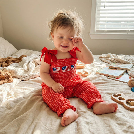 Child in a red checkered outfit with American flags - ChildAngle 4th of July Baby Romper