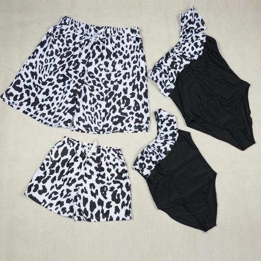 Leopard print top and shorts with black swimsuit on a beige background