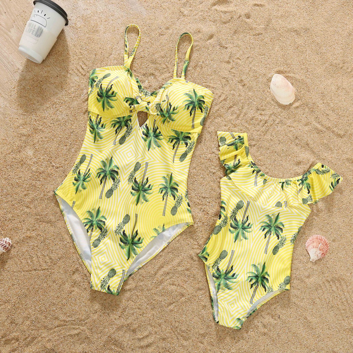 Yellow swimsuits with palm tree pattern on a sandy surface