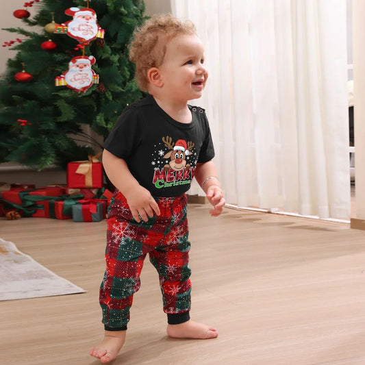 Child wearing Christmas-themed pajamas in front of a decorated tree Reindeer Merry Christmas Matching Christmas PJS Snowflake Short Sleeve Family Matching Pyjamas Set