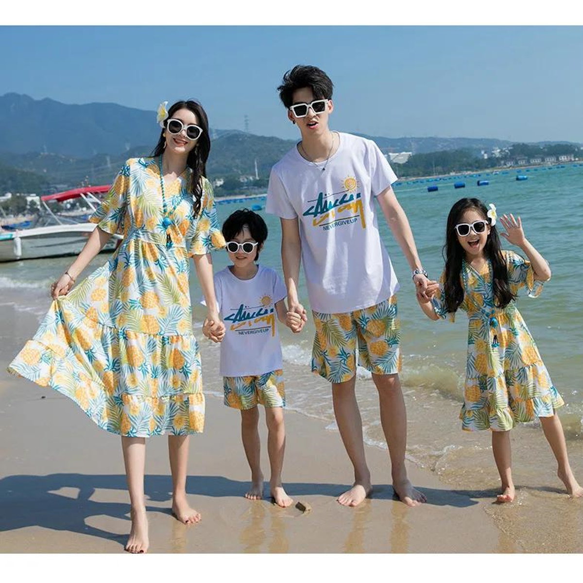 Family of four wearing matching outfits on a beach with boats and mountains  Pineapple Family Matching Outfits - ChildAngle