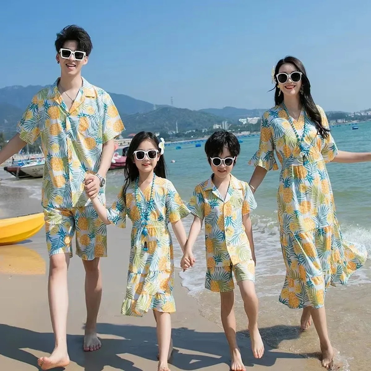 Family of four in matching beach outfits standing on a sandy beach with ocean and mountains in the background  Pineapple Family Matching Outfits - ChildAngle