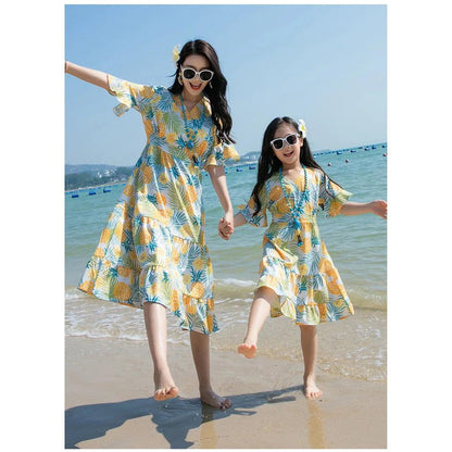 Two women in matching yellow and blue patterned dresses on a beach  Pineapple Family Matching Outfits - ChildAngle