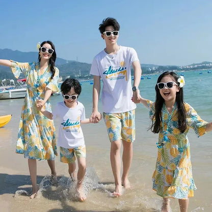 Family of four in matching beachwear standing on a sandy beach with ocean and mountains  Pineapple Family Matching Outfits - ChildAngle