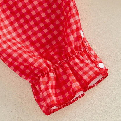 Child in a red checkered outfit with American flags - ChildAngle 4th of July Baby Romper