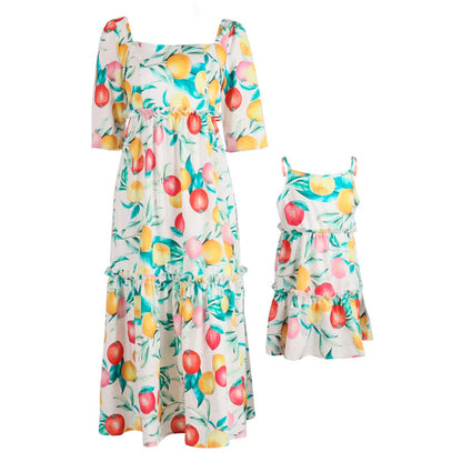 Fruit-patterned dresses for mom and daughter on a white background