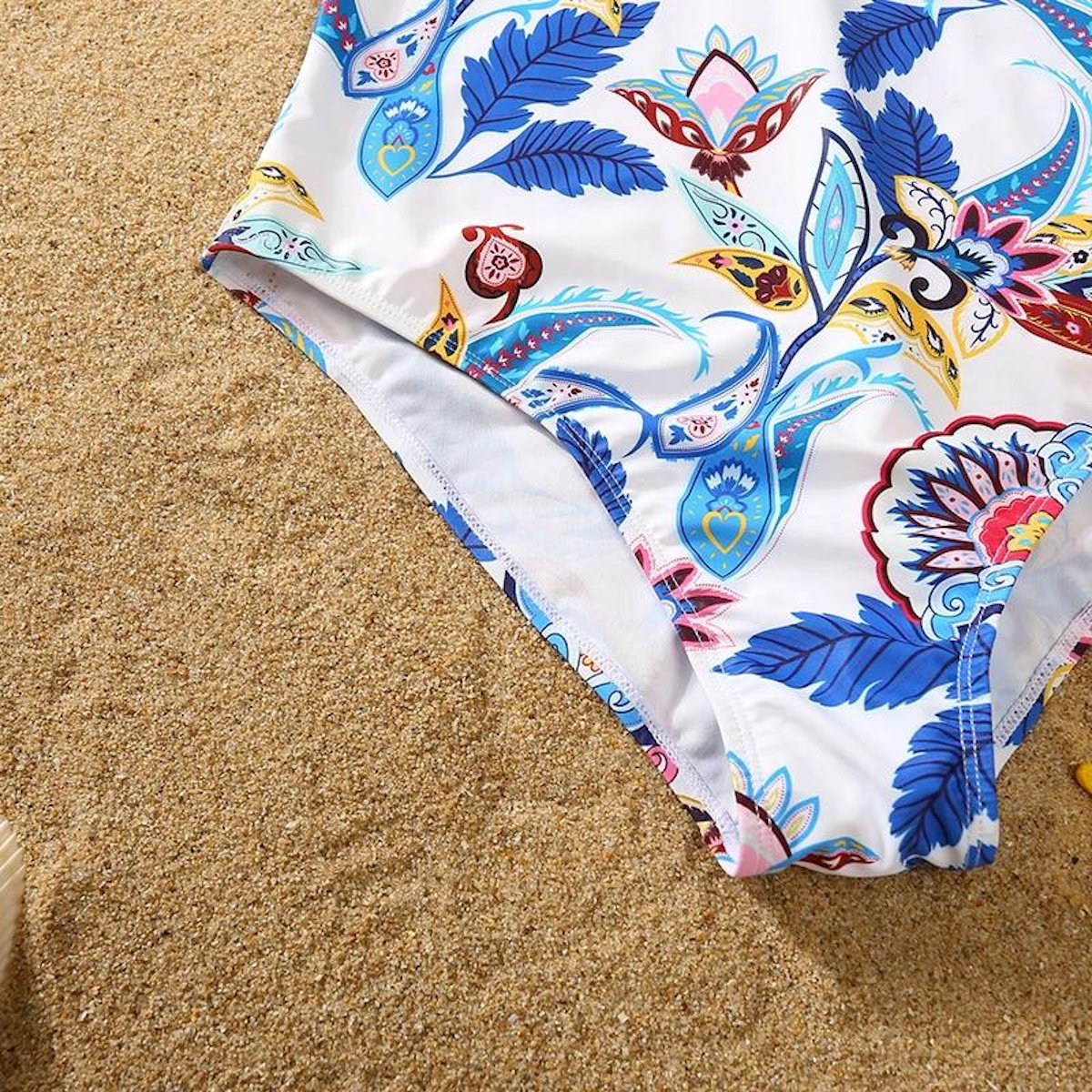 Colorful floral-patterned swimsuit bottom on sand