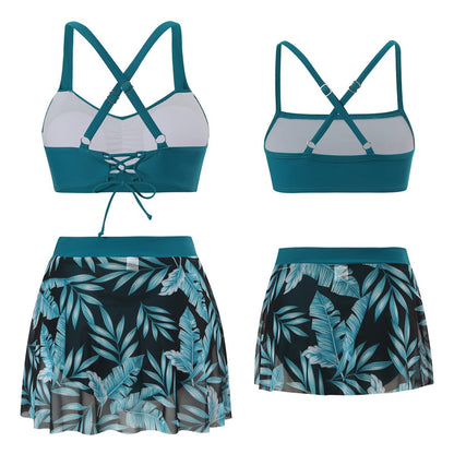Teal bikini set with matching skirt featuring leaf pattern on a white background