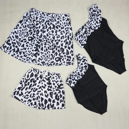 Leopard print top and shorts with black swimsuit on a beige background