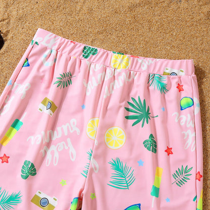Pink shorts with colorful tropical patterns on a sandy background