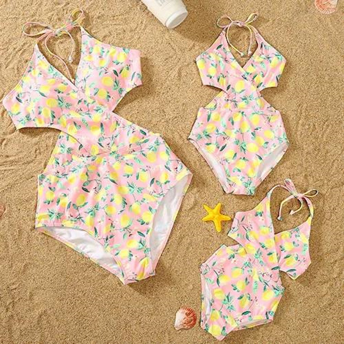Pink swimsuit with lemon pattern on a sandy background
