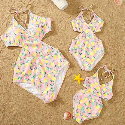 Pink swimsuit with lemon pattern on a sandy background