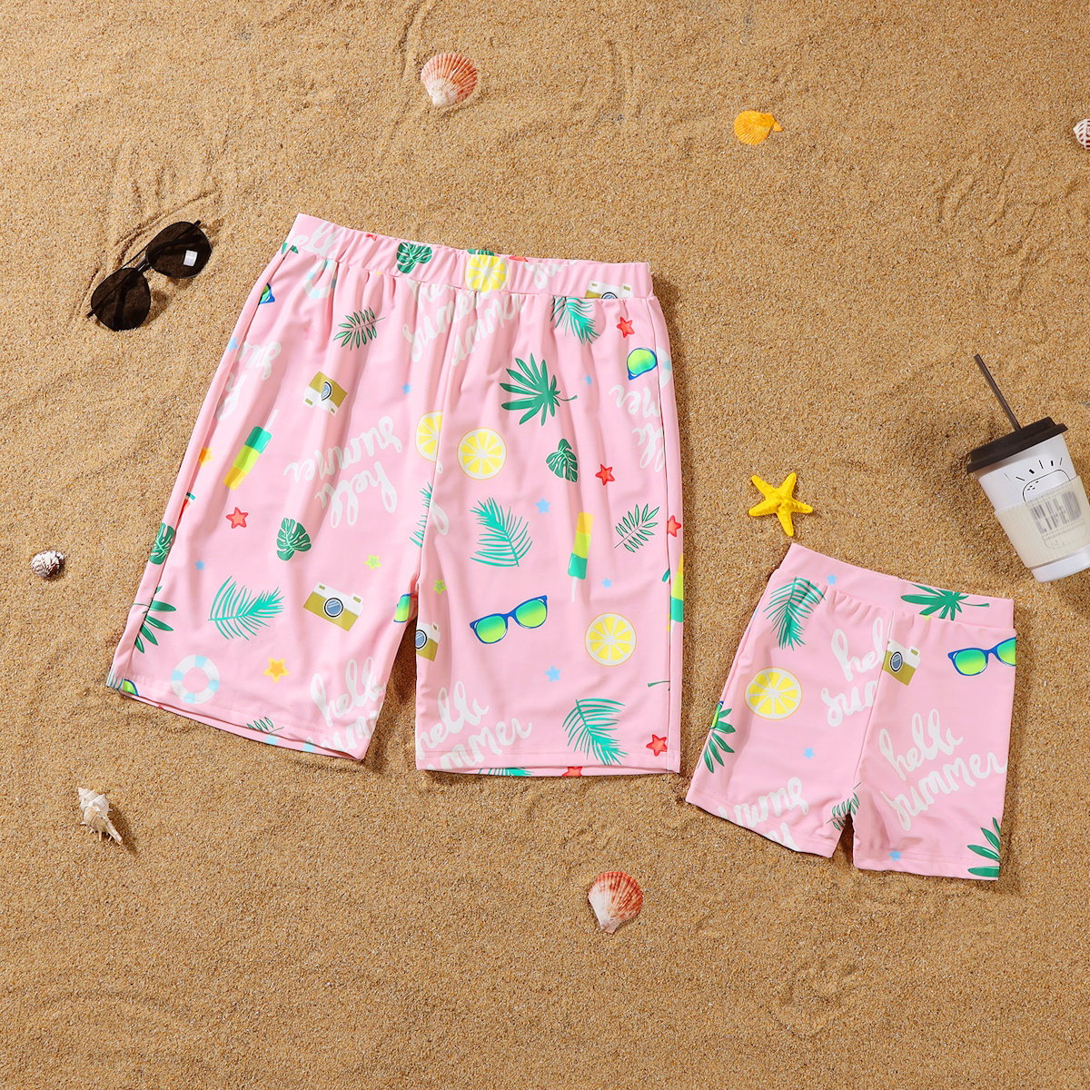 Pink shorts with tropical pattern on a sandy background