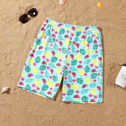 Colorful tropical fruit patterned shorts on a sandy background