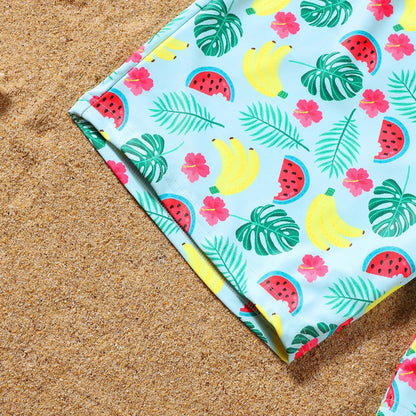 Colorful beach towel with tropical pattern on sand