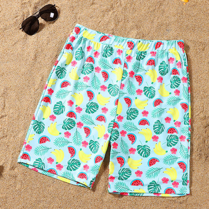Colorful patterned shorts on a sandy surface with sunglasses.
