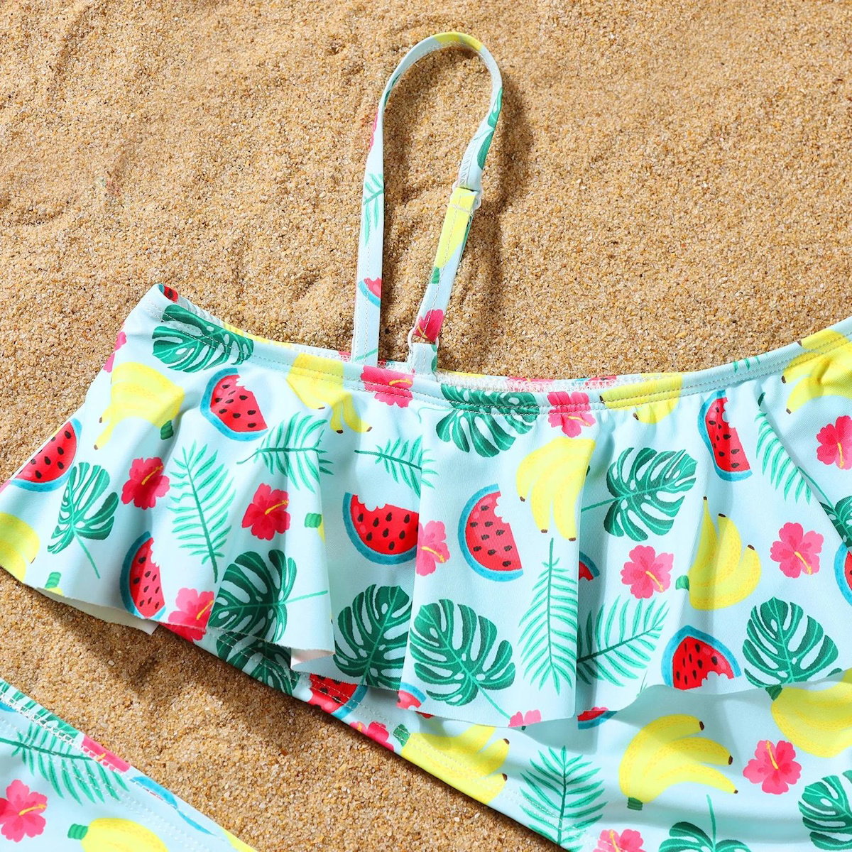 Tropical-themed bikini top on a sandy background