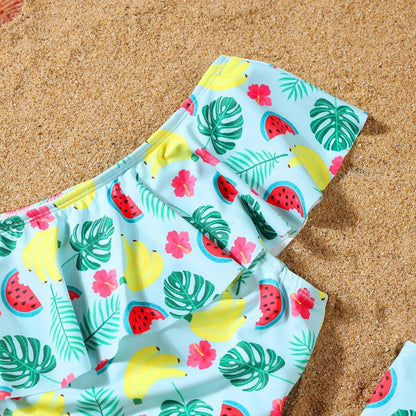 Colorful swimsuit with tropical pattern on a sandy background
