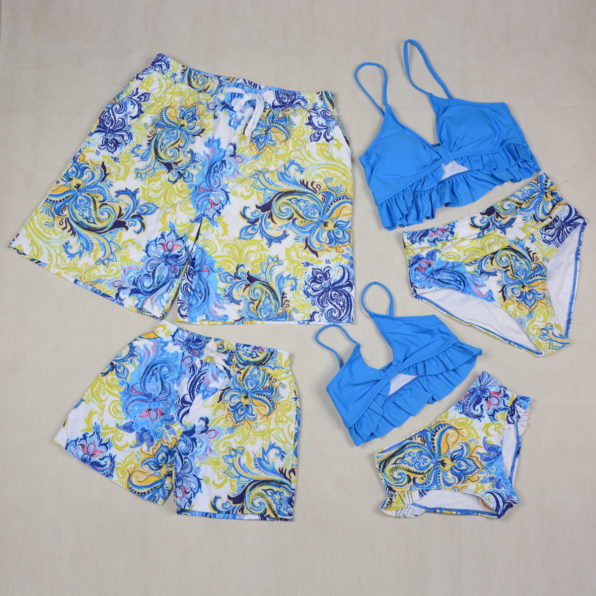 Blue and yellow patterned swimwear set on a beige background