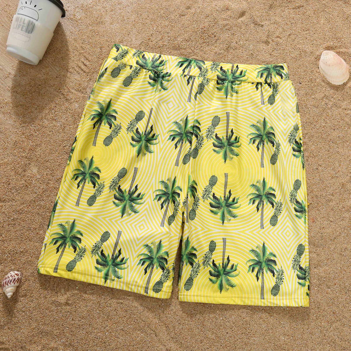 Yellow shorts with palm tree pattern on a sandy background