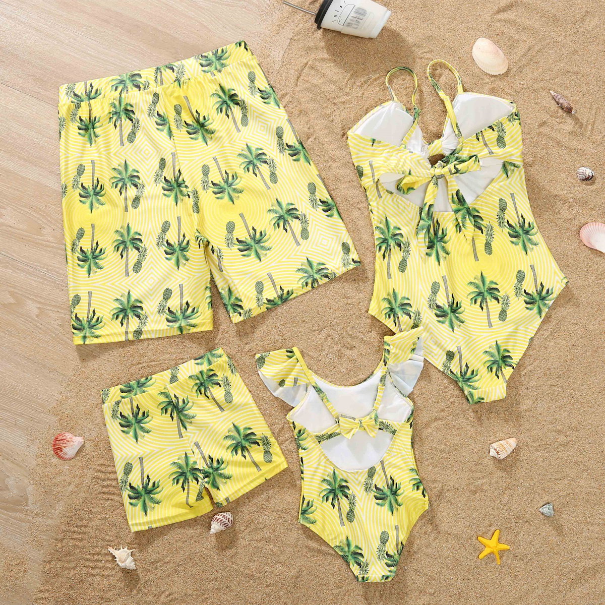Yellow children's swimwear set with palm tree pattern on sand