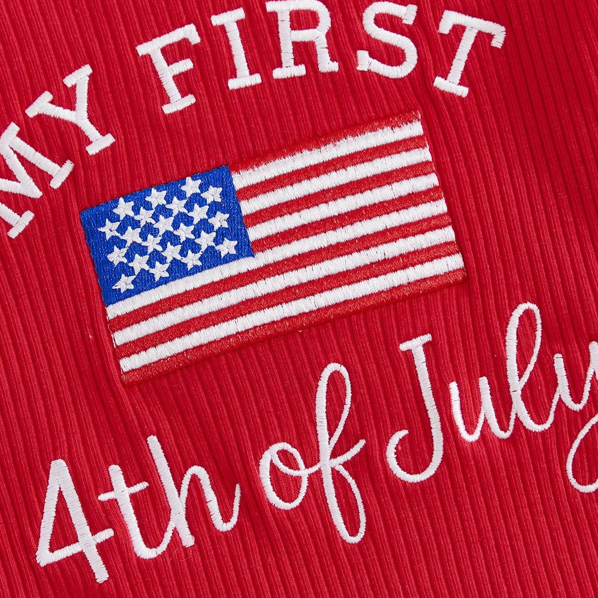 Red fabric with white embroidered text 'My First 4th of July' and an American flag patch - ChildAngle