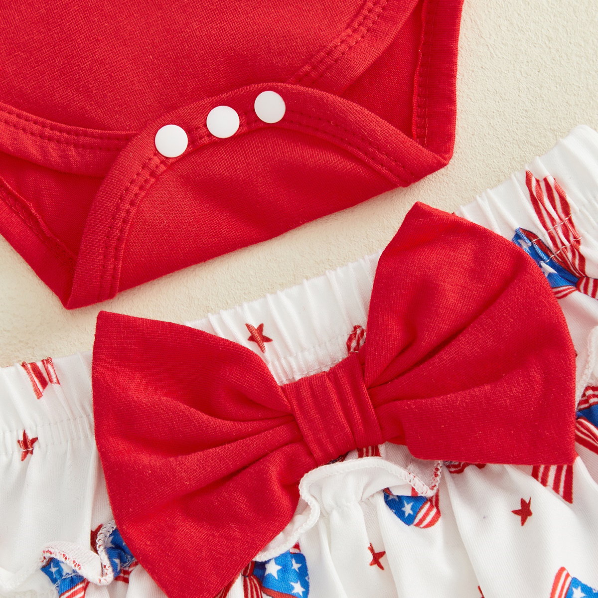Red baby outfit with a large bow on white tiered shorts for the first 4th of July - ChildAngle