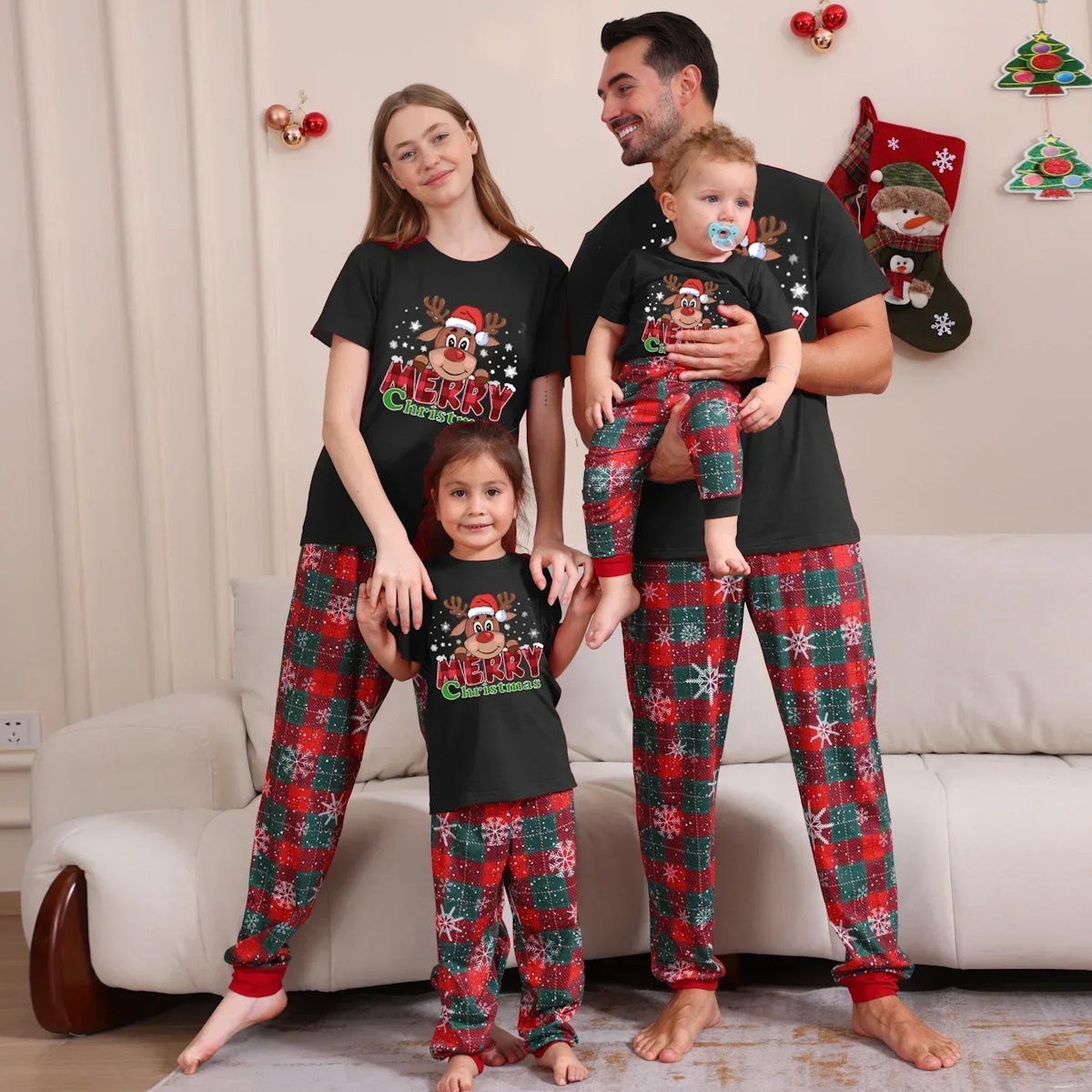 Family of four wearing matching Christmas pajamas in a living room setting - ChildAngle